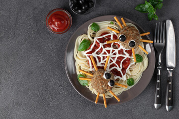 Cutlets look like spiders with olive eyes and straws, served with spaghetti pasta and tomato sauce. Halloween breakfast, Top view