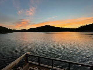 Poster - Beautiful shining golden, orange sunset reflected on surface of undulating lake on summer evening