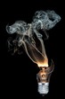 Vertical closeup shot of a burned-out light bulb with smoke coming out