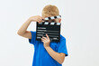 Funny smiling child boy hold film making clapperboard isolated on white background. Studio portrait. Childhood lifestyle concept. Copy space for text