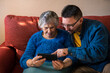 © REC Stock Footage - Grandma holding smartphone to call with her grandson sitting on living room.