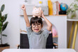 © FAMILY STOCK - Little Asian girl saving money in a piggy bank, learning about saving, Kid save money for future education. Money, finances, insurance, and people concept