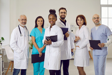 Group portrait of diverse multiethnic doctors in medical uniform pose in clinic. Smiling multiracial medicine workers or professionals show good health service in hospital. Healthcare concept.