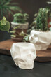 © Gulsina - White pots for plants with succulents in the shape of a skull made of plaster, concrete. Creative Halloween floral concept. Fashion minimal art.