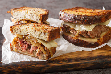 Wall Mural - classic beef patty melt sandwich using crispy rye bread, cheese, and tender onions closeup on the wooden board on the table. Horizontal