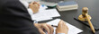 © Puwasit Inyavileart - Lawyers or judges sign documents in accordance with legal and fair terms of agreement, Legal Ethics and Integrity, scales of justice, law hammer, Litigation and legal services.