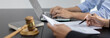 © Puwasit Inyavileart - Lawyers or judges sign documents in accordance with legal and fair terms of agreement, Legal Ethics and Integrity, scales of justice, law hammer, Litigation and legal services.