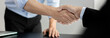 © Puwasit Inyavileart - Businessman shaking hands with a lawyer or judge After signing the contract and the agreement is complete, Approval of an agreement between business and law, End of the legal case.