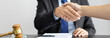© Puwasit Inyavileart - Businessman shaking hands with a lawyer or judge After signing the contract and the agreement is complete, Approval of an agreement between business and law, End of the legal case.