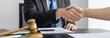 © Puwasit Inyavileart - Businessman shaking hands with a lawyer or judge After signing the contract and the agreement is complete, Approval of an agreement between business and law, End of the legal case.