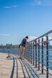 © Alina Lebed - Children and a man walk across the bridge and look at the river. Various interesting things are attached to the railing. A hot summer day