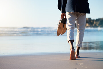 walking, beach and mental heath with a business man walking in the sand by the sea or ocean after wo