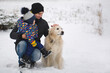 © Studio Peace - Dad and son play with the dog in the snow. Golden Retriever
