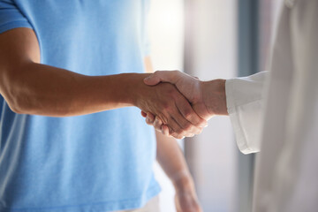 Handshake, trust and respect with a patient and medical worker or doctor shaking hands, greeting or introduction during consultation. Closeup of men with thank you gesture or welcome, agree or greet