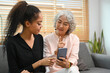© Prathankarnpap - Grownup daughter teaching interested retired mother using social networks on smart phone. Elderly, technology concept