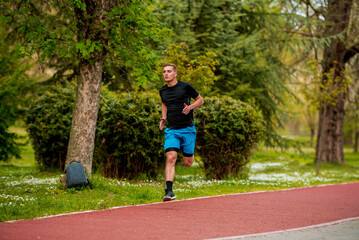 Wall Mural - Male athlete in sprint run wearing sports running shoes and shorts in workout for marathon