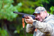 © Евгений Панов - Shotgun barrel, hunting gun in selective focus in the hands of a blurred hunter.