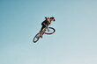 © Clement C/peopleimages.com - Motorcycle stunt, man cycling in air jump on blue sky mock up for sports action performance, fitness training or outdoor bike performance. Professional sports person with bmx bicycle adventure mockup