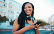 © N Lawrenson/peopleimages.com - Student, street and happy girl with smartphone enjoying leisure break on weekend in Los Angeles. Black woman hipster with smile on commute with phone and headphones for music streaming in city.