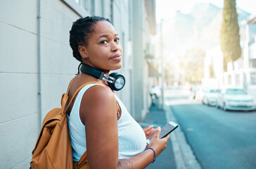 black woman in street with smartphone and headphones for city, outdoor or youth lifestyle with music
