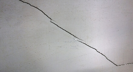 A crack on the wall of a building after an earthquake. The wall broke into two parts. Major renovation of the apartment. Poor-quality wall decoration.