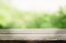 Empty Rustic Wooden Table Against Green Blurred Background 
