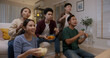 © ChayTee - Group of young adult friend man and woman asia people sit at sofa couch joy night party fun game FIFA world cup live TV at home eat snack bowl drink beer bottle glass jump mad happy win exult face