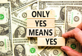 Wall Mural - Only yes means yes symbol. Concept words Only yes means yes on wooden blocks on a beautiful background from dollar bills. Businessman hand. Business, psychological only yes means yes concept.