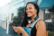 © N Lawrenson/peopleimages.com - Student, phone and black woman in street with headphones on walk to college in south africa. Happy, smile and beautiful african girl in outdoor city road networking on social media with smartphone.