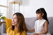 © BritCats Studio - Asian mother and daughter embrace and playing together with happiness and smile inside of living room. Mom and children relationship positive emotion with copy space for text.