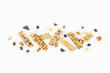 Top view of various homemade granola bars with nuts, seeds, dark chocolate, honey and berries over a white background.