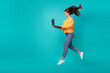 Full length photo of young attractive funny woman jump air trampoline hold computer distant work education empty space isolated on cyan color background