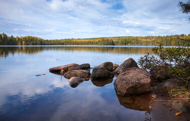 Wall Mural - low angle view of a calm lake with rocks in northern minnesota on a beautiful autumn day