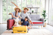 © aekkorn - Happy family tourist portrait. Father, mother and a daughter ready for travel flight posing to camera with suitcase.