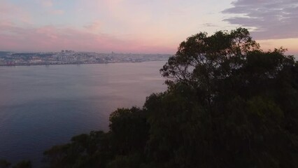 Poster - Famous Lisbon from the tree branches on a dramatic sunset