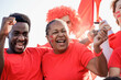 © Vane Nunes - African football fans celebrating and supporting their team at sport stadium - Focus on senior woman face