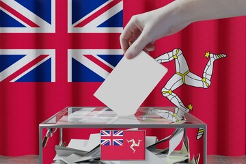 Wall Mural - Isle of Man flag, hand dropping ballot card into a box - voting/ election concept - 3D illustration