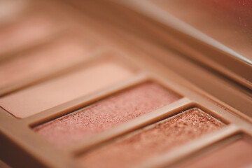 Wall Mural - Eye shadow palette in pink rose gold and nude colors closeup. Makeup cosmetic product. Selective focus.