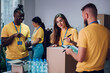 © Zamrznuti tonovi - Group of multiracial volunteers working in community charity donation center