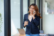 © amnaj - Smiling Asian businesswoman enjoying the phone, answering questions, talking to customers on the phone and comment in the office.