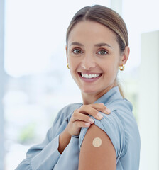 portrait of woman with a plaster on her arm from vaccine or an injection. young, smiling woman with 