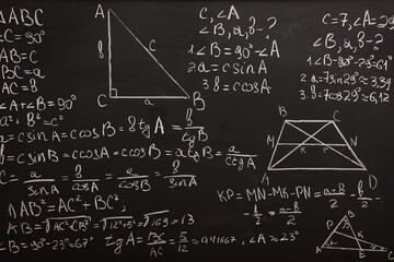 Different mathematical formulas written with chalk on blackboard