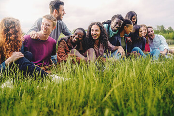 Diverse generation z young people hugging in the park - people lifestyle concept