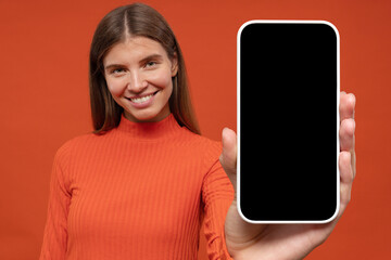 Happy young woman holding blank phone screen with copy space for your app