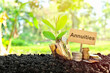 Investment on annuities concept. Coins in a jar with soil and growing plant in nature background.
