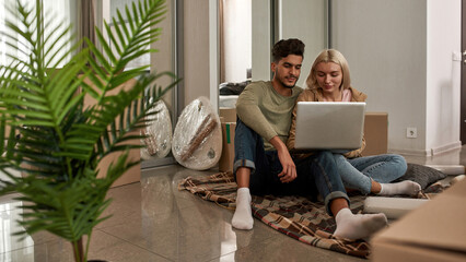 Wall Mural - Couple use and watch laptop on blanket on floor