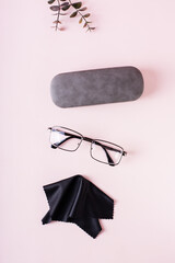 Wall Mural - Case, glasses  and cleaning cloth on a pink background. Storage and care. Top and vertical view