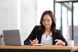 © wichayada - Beautiful Asian businesswoman analyzes charts using laptop calculator at the office.