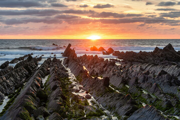 Wall Mural - Beautiful sunset landscape image of Welcome Mouth Beach in Devon England with beautiful rock formations