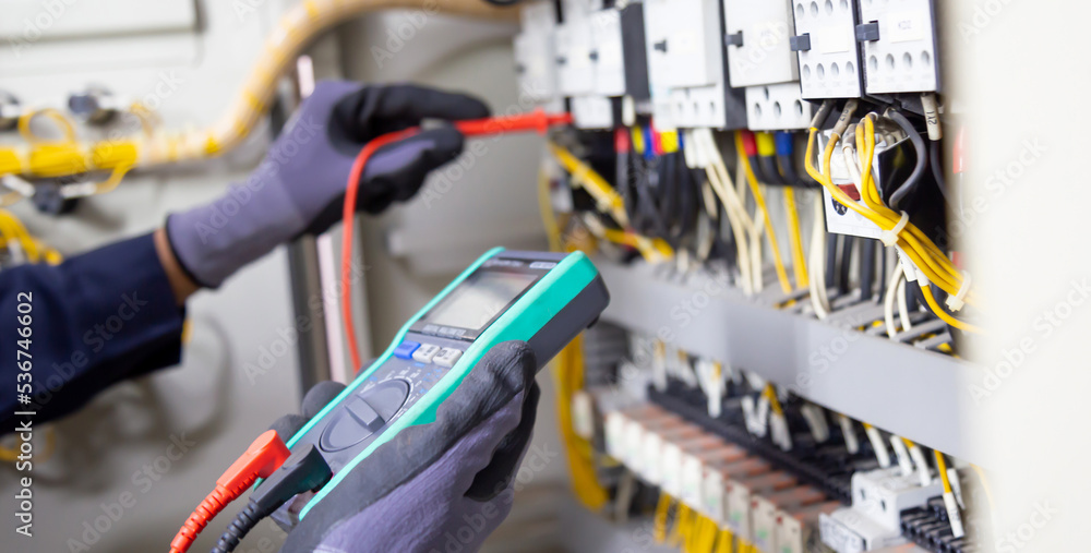 Electrician engineer tests electrical installations and wires on relay ...